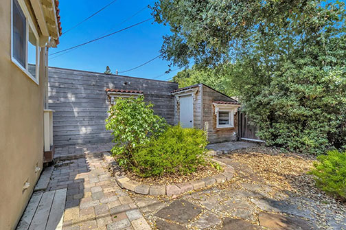 shed with red tile roof over window