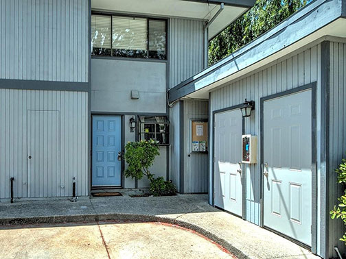 front of unit with garages from inside the fence